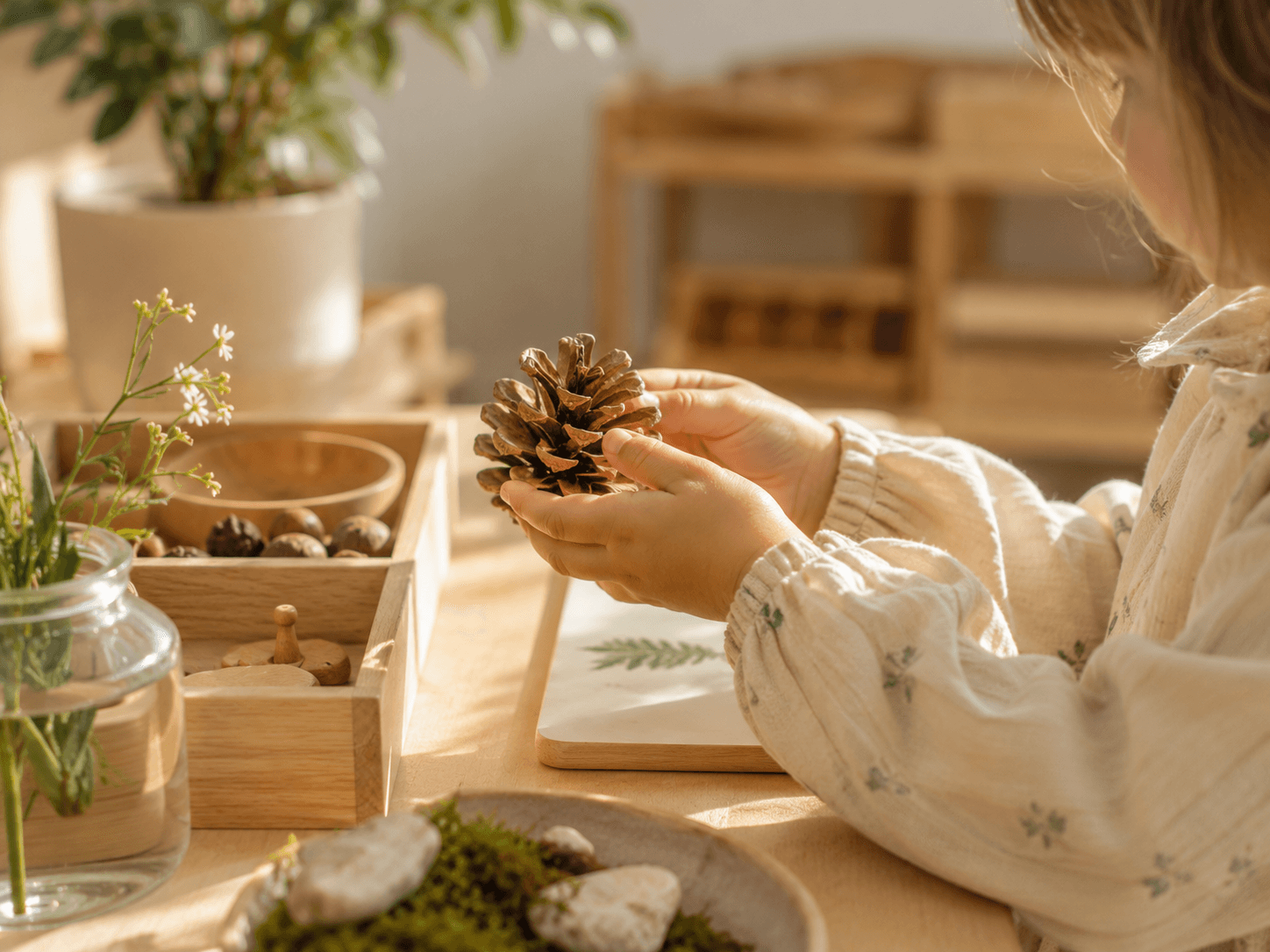 Enfant manipulant un élément naturel dans une ambiance Montessori douce